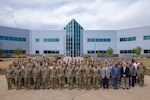 More than 100 logisticians and planners from across the joint logistics enterprise gather for a group photo during the 2026 Sustainment Rehearsal of Concept (ROC) Drill at North American Aerospace Defense Command and U.S. Northern Command headquarters on April 28, 2026. The collaborative event brought together N&NC staff, service components, Canadian allies and interagency partners to physically walk through continental distribution concepts, identify critical nodes and strengthen the homeland defense network. (Department of War photo by Blake Macias)