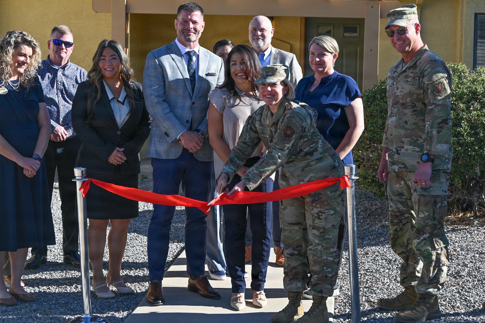 U.S. Air Force Col. Kelly Padden, 377th Mission Support Group commander, cuts a ribbon at the Pershing Housing Renovation Completion Ribbon Cutting at Kirtland Air Force Base, New Mexico.