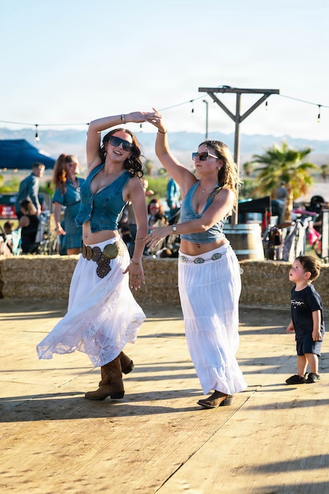 Attendees dance together during the 2026 We Salute You Celebration at Victory Field, Marine Corps Air Ground Combat Center Twentynine Palms, California, May 8, 2026. The annual event features live music, games and activities as a way to honor service members aboard MCAGCC. (U.S. Marine Corps photo by Lance Cpl. Gracelyn Hanson)