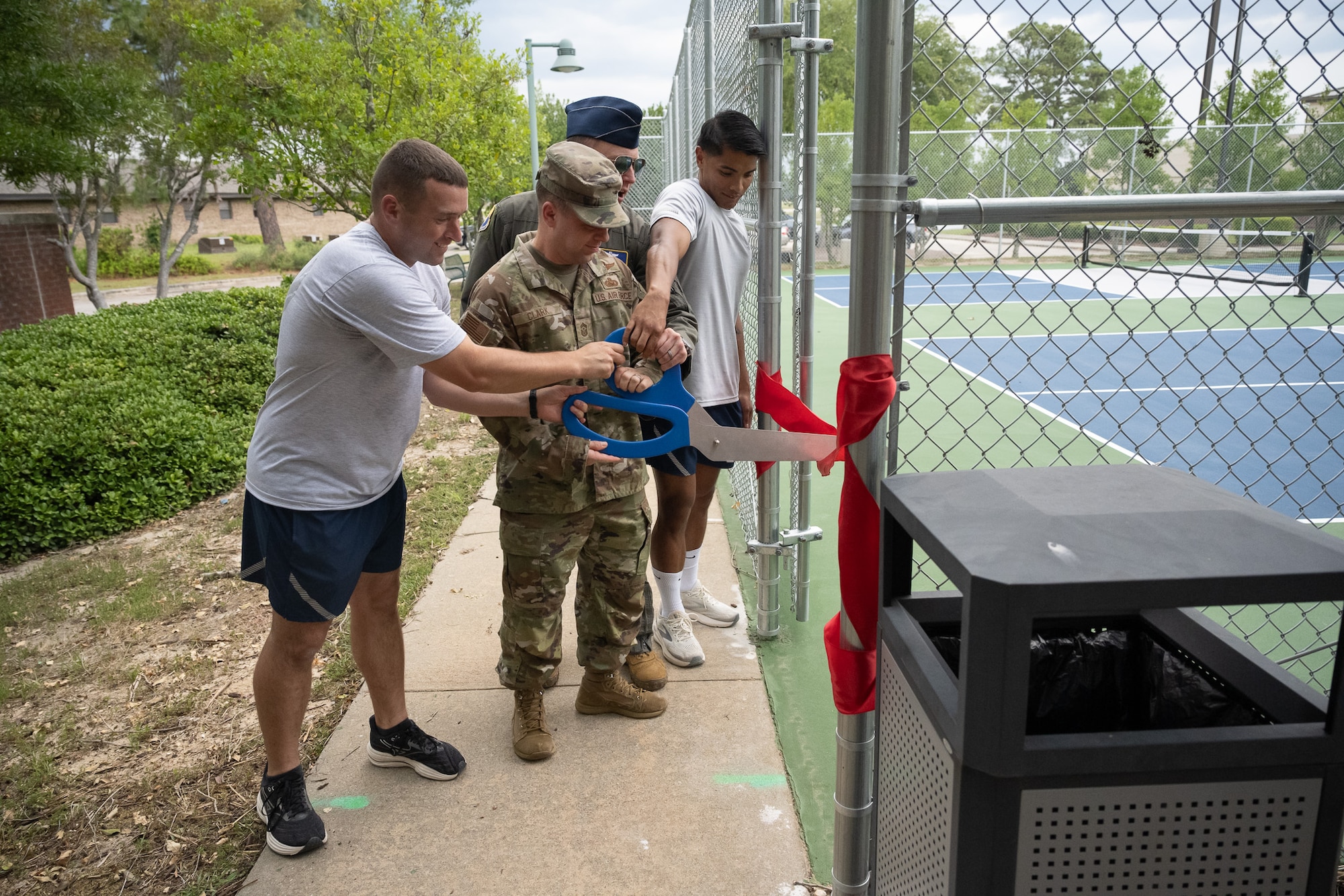 Four people cut a ribbon.