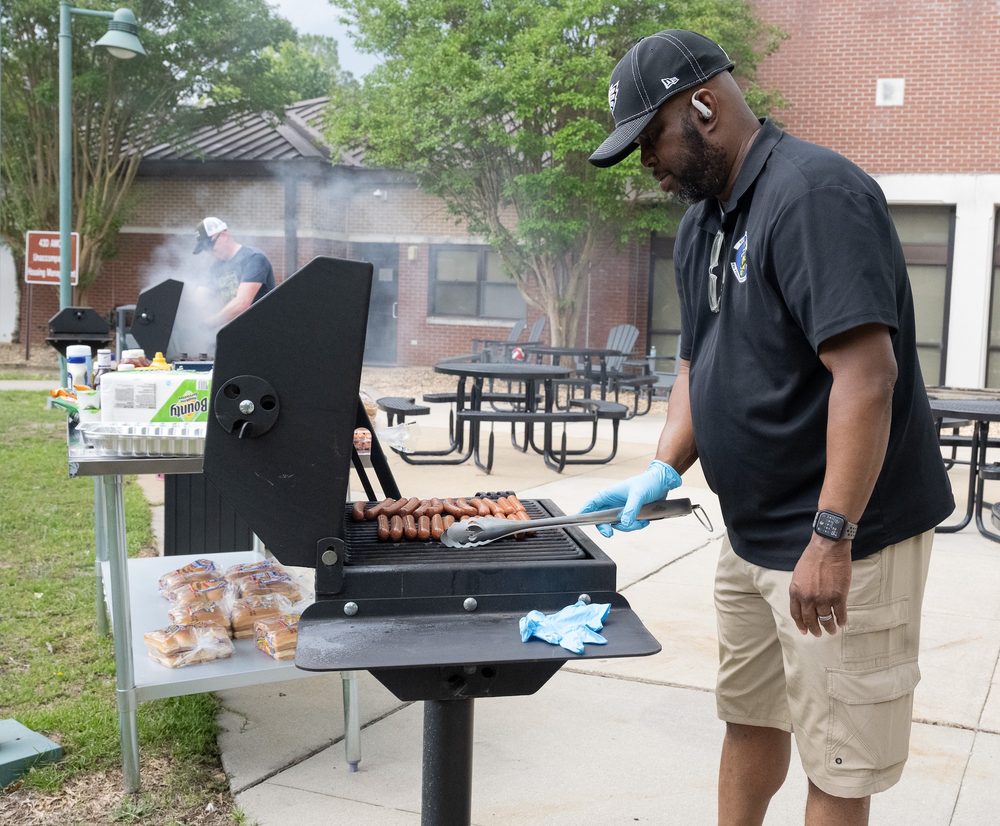 A man grills hot dogs.