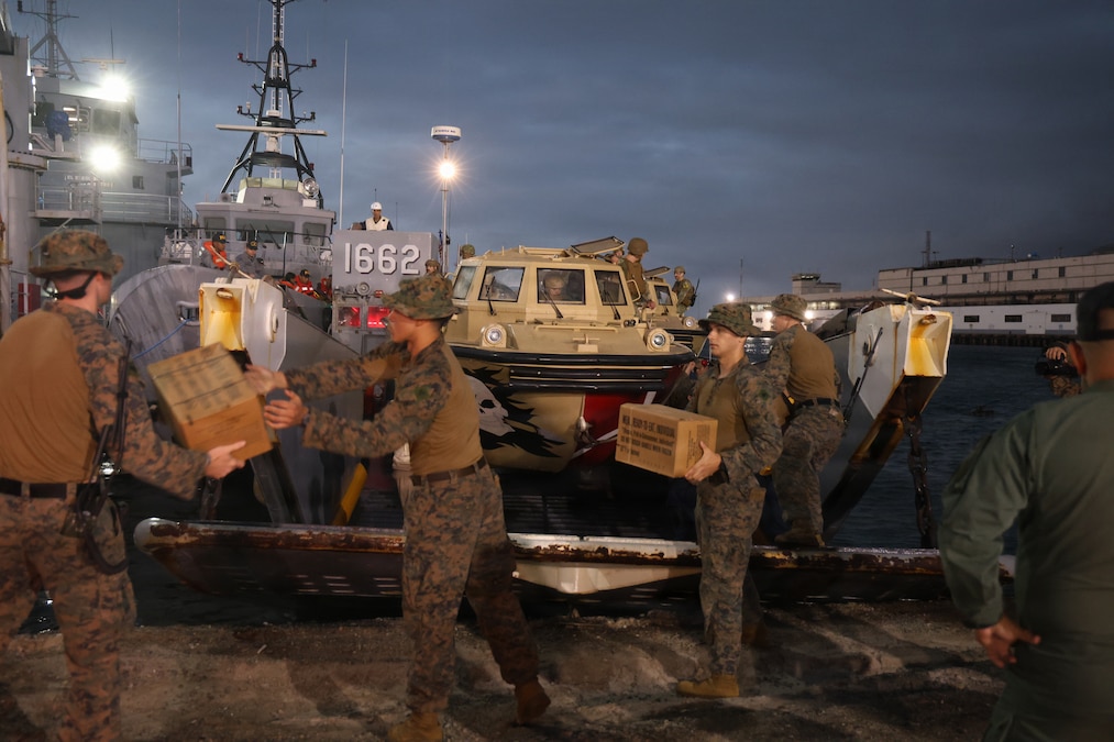 Troops carry boxes of supplies.