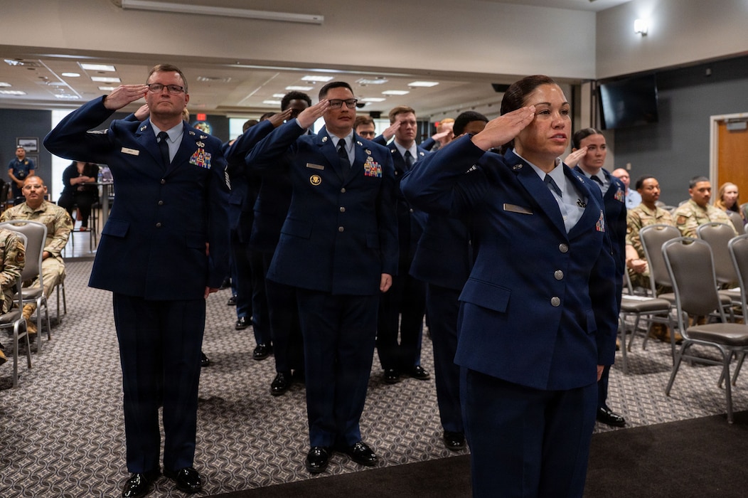 Service members in a formation render a salute