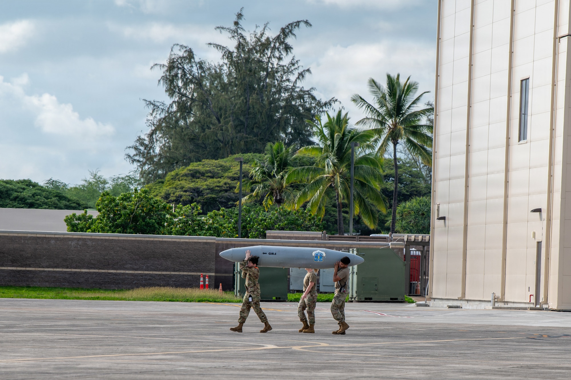 U.S. Airmen assigned to the 115th Fighter Wing, Wisconsin Air National Guard, relocate downloaded travel pods during post-flight operations during exercise Sentry Aloha 26-1 at Joint Base Pearl Harbor-Hickam, Hawaii, Jan. 11, 2026. Sentry Aloha is built around Dissimilar Air Combat Training, which challenges pilots to engage in combat scenarios against aircraft with different performance capabilities. (U.S. Air National Guard photo by Master Sgt. Mary Greenwood) This photo was altered for security purposes by blurring out identification badges.