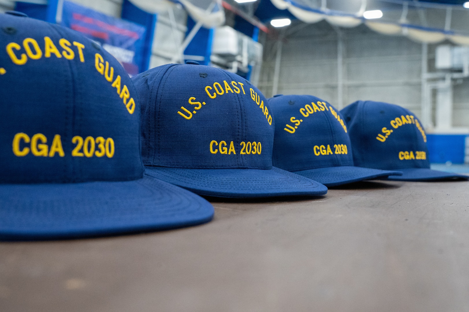 U.S. Coast Guard Academy (USCGA) covers for the class of 2030 stationed on a table at USCGA, New London, Connecticut, June 29, 2026. This ceremony marks their official entrance into the seven-week training program which will prepare them for becoming cadets. (U.S. Coast Guard photo by Petty Officer Third Class Roxanna Jacobo Cruz)
