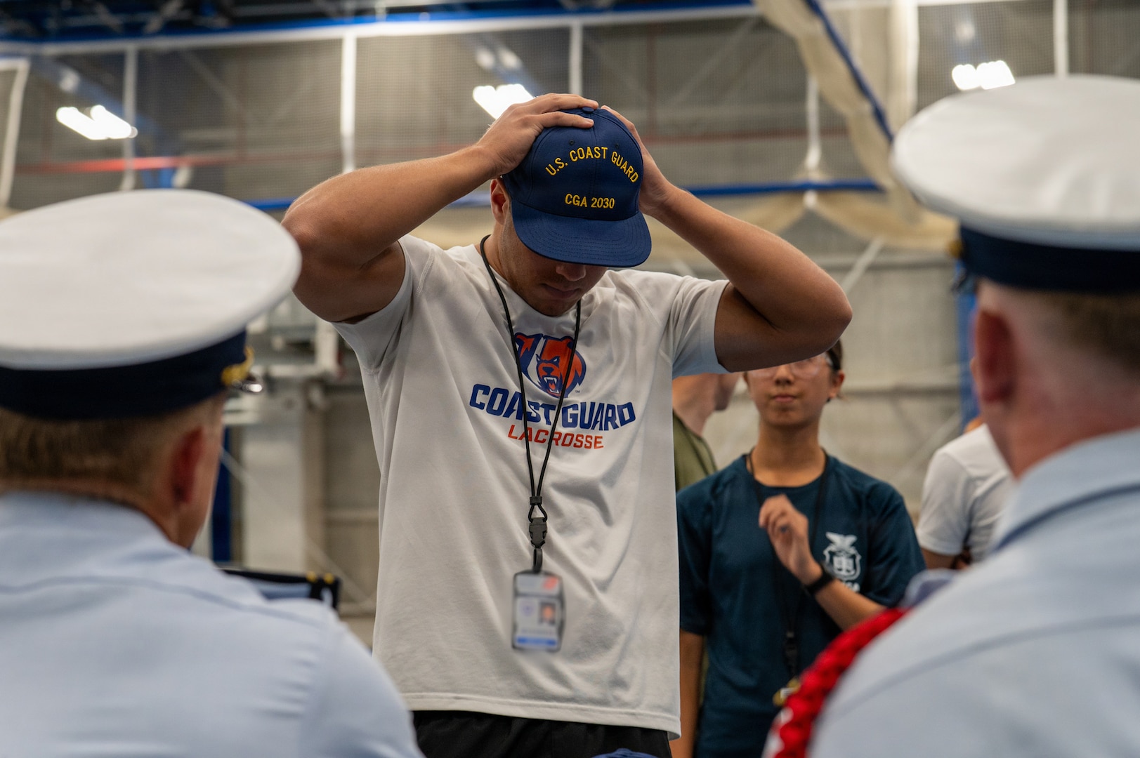 U.S. Coast Guard Academy (USCGA) Class of 2030 swabs try on covers during check in at USCGA, New London, Connecticut, June 29, 2026. Day One marks the start of Swab Summer, an intensive seven-week program that prepares students for military and Academy life. (U.S. Coast Guard photo by Petty Officer Third Class Roxanna Jacobo Cruz)