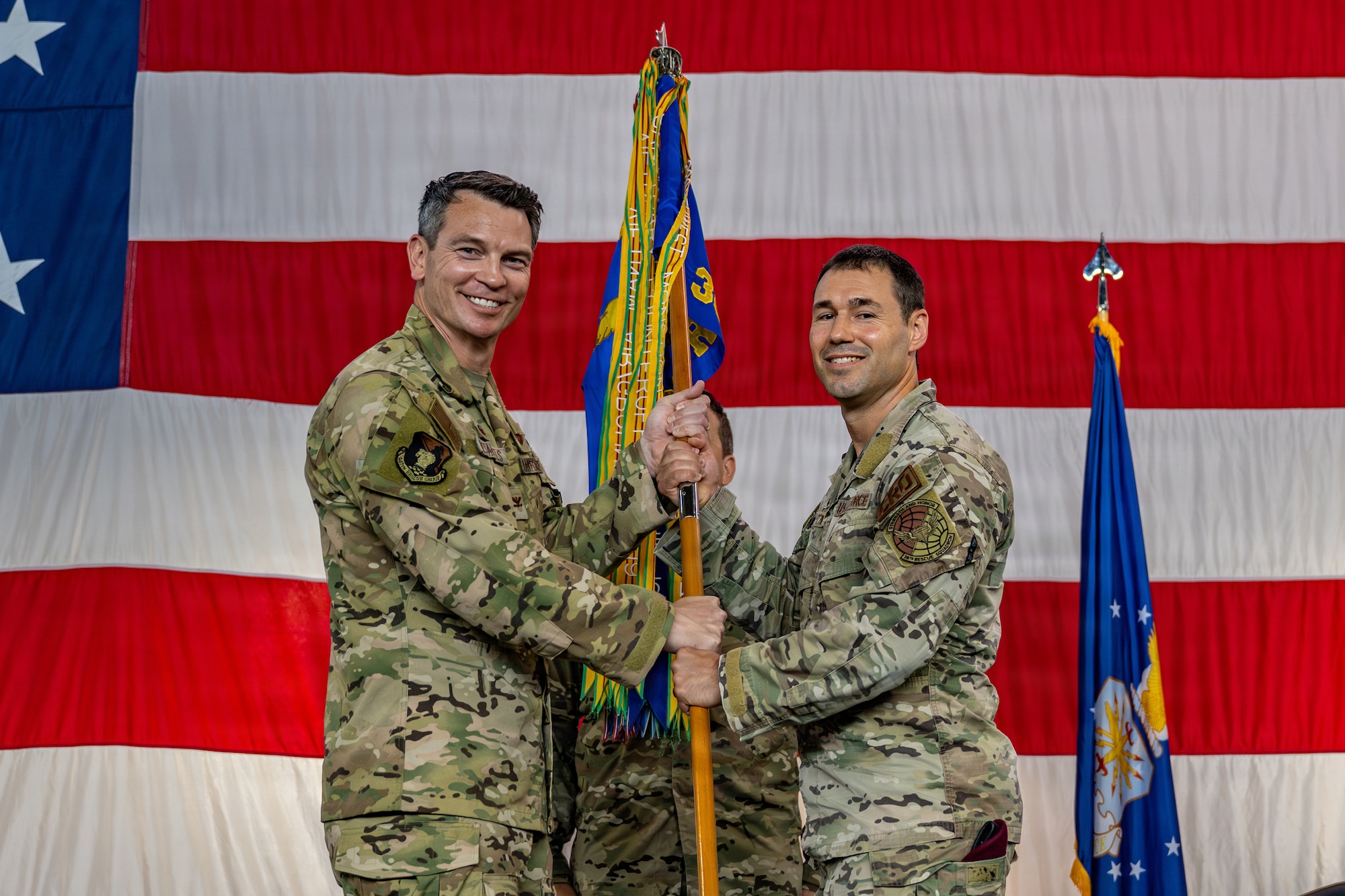 U.S. Air Force Lt. Col. Ryan Witzig, right, assumes command of the 38th Rescue Squadron as he receives the guidon from Col. Brian Desautels, 347th Rescue Group commander, during a change of command ceremony at Moody Air Force Base, Georgia, June 29, 2026