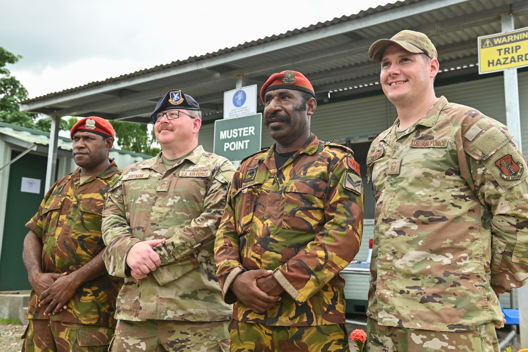 From the left, Papua New Guinea Defence Force Lance Corporal Wilfred Pomun, assigned to the PNGDF Air Transport Wing, U.S. Air Force Senior Master Sgt. Joshua Justman assigned to the 128th Air Refueling Wing, Wisconsin Air National Guard, PNGDF Corporal Arthur Wariambu, assigned to the PNGDF ATW and U.S. Air Force Senior Master Sgt. Nathan Silvers assigned to Volk Field, WI ANG, pose for a photo while securing an entry control point at the PNGDF ATW, in the National Capitol District, Port Moseby, Papua New Guinea March 14, 2025.  The Wisconsin National Guard State Partnership Program is working with the U.S. Embassy team in PNG, and the PNG Defence Force on a consolidated exchange in PNG during fiscal year 2025 that includes four subject matter expert exchanges. (U.S. Air National Guard photo by Master Sgt. Mary Greenwood)