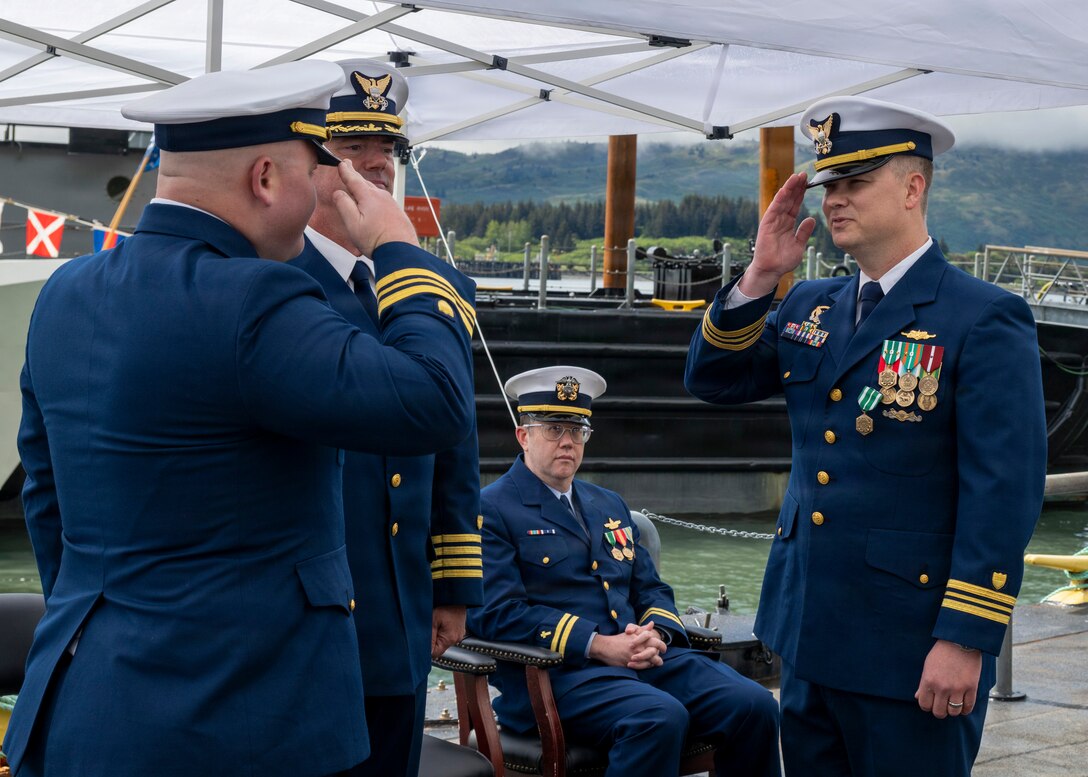 Coast Guard Lt. Cmdr. Matthew Panciocco (left), incoming commanding officer of Coast Guard Cutter John Witherspoon (WPC 1158), assumes the role of commanding officer of the Witherspoon from Lt. Cmdr. Michael Adam Young (right), outgoing commanding officer of the Witherspoon, during the cutter's change of command ceremony at Paradigm Pier in Kodiak, Alaska, June 16, 2026. Capt. Joel Carse, commander of Coast Guard Sector Western Alaska and U.S. Arctic, presided over the ceremony. (U.S. Coast Guard photo by Petty Officer 1st Class Shannon Shepard)