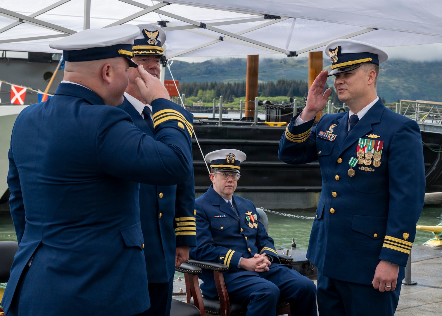 Coast Guard Lt. Cmdr. Matthew Panciocco (left), incoming commanding officer of Coast Guard Cutter John Witherspoon (WPC 1158), assumes the role of commanding officer of the Witherspoon from Lt. Cmdr. Michael Adam Young (right), outgoing commanding officer of the Witherspoon, during the cutter's change of command ceremony at Paradigm Pier in Kodiak, Alaska, June 16, 2026. Capt. Joel Carse, commander of Coast Guard Sector Western Alaska and U.S. Arctic, presided over the ceremony. (U.S. Coast Guard photo by Petty Officer 1st Class Shannon Shepard)