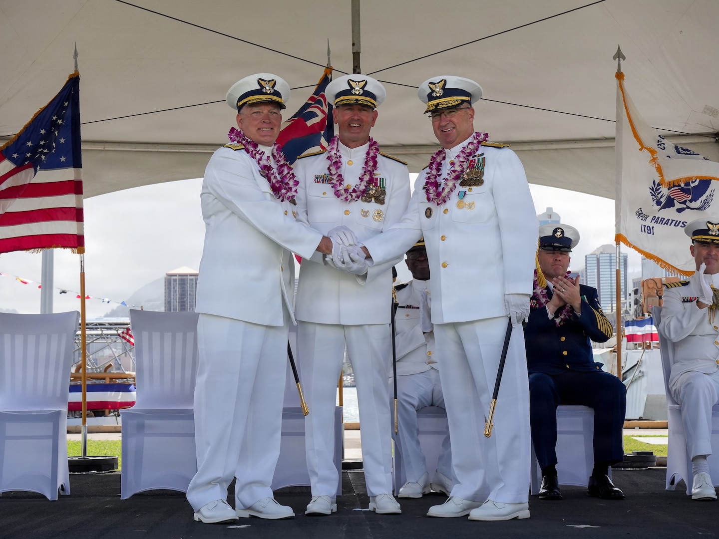Vice Adm. Buzzella, Rear Adm. Regan, and Rear Adm. Arguin shake hands.