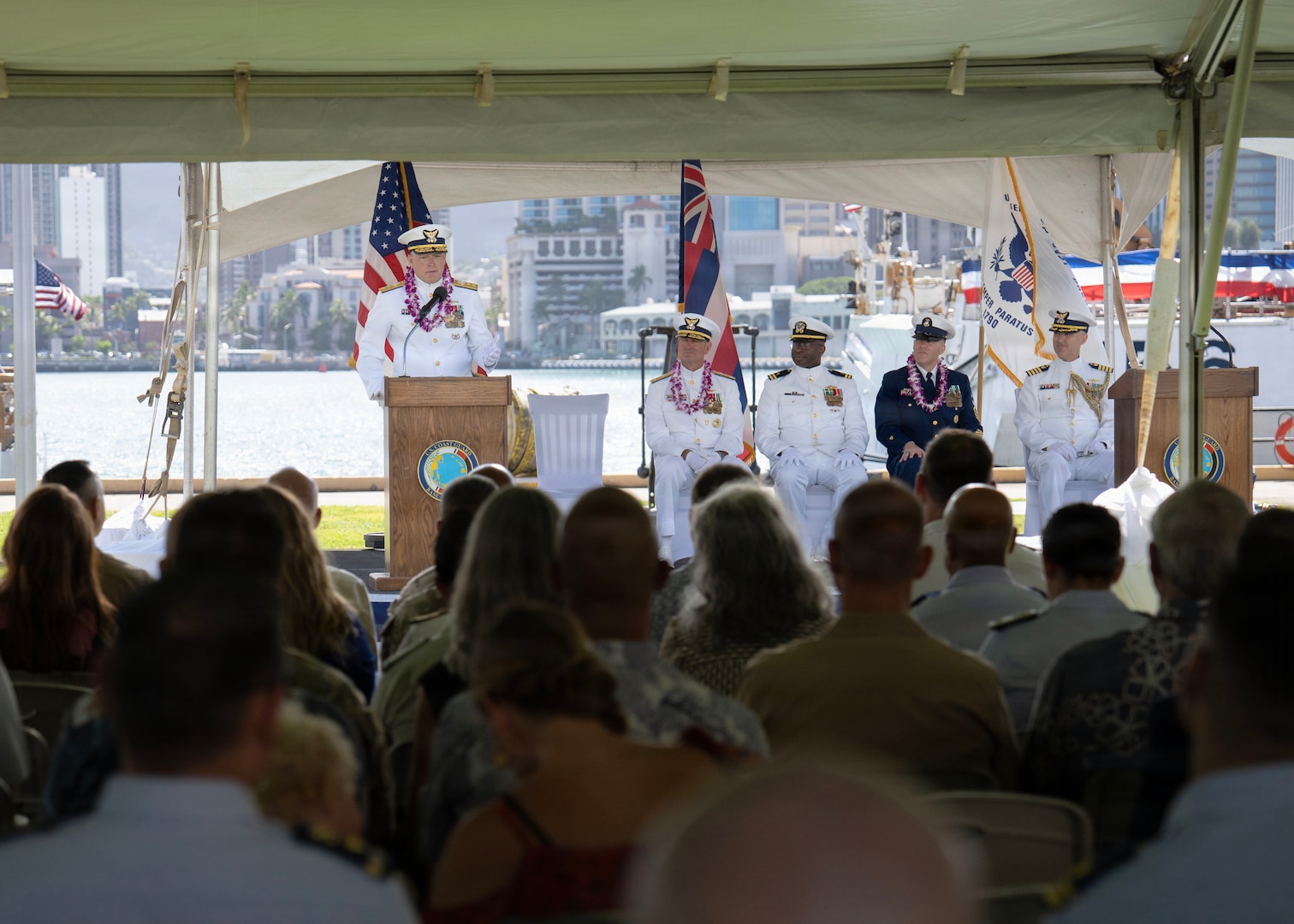 Rear Adm. Arguin speaks to a crowd. He is wearing his Coast Guard dress whites.
