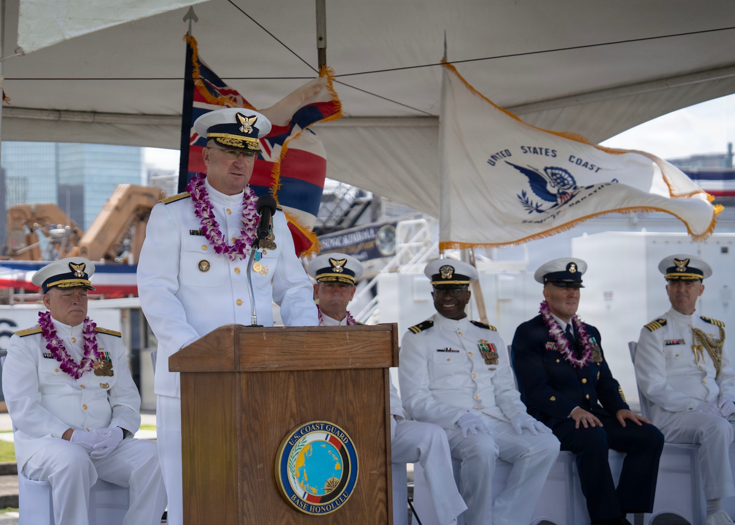 Rear Adm. Regan speaks to a crowd. He is wearing his Coast Guard dress whites.