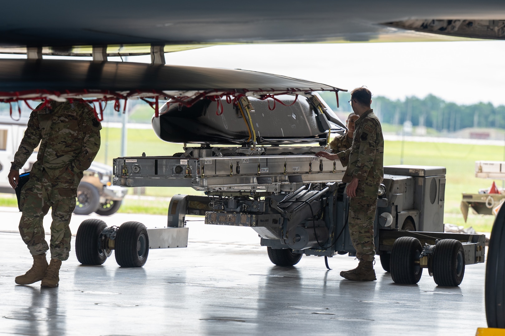 A cruise missile is loaded onto a stealth bomber