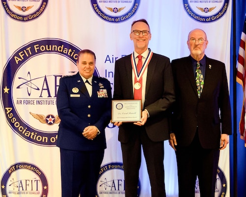 The Air Force Institute of Technology and the AFIT Foundation and Association of Graduates recognized five alumni for their outstanding career achievements in a ceremony on June 19.  Lt. Gen. Linda S. Hurry, commander, Air Force Materiel Command, and AFIT alumnus, was the featured speaker.  The 2025 Distinguished Alumni Award was presented to Orval Powell (center), by Lt. Gen. Linda S. Hurry, commander, Air Force Materiel Command (left) and Dr. Lance Chenault, AFIT Foundation and Association of Graduates president (right).  (Contributed photo)