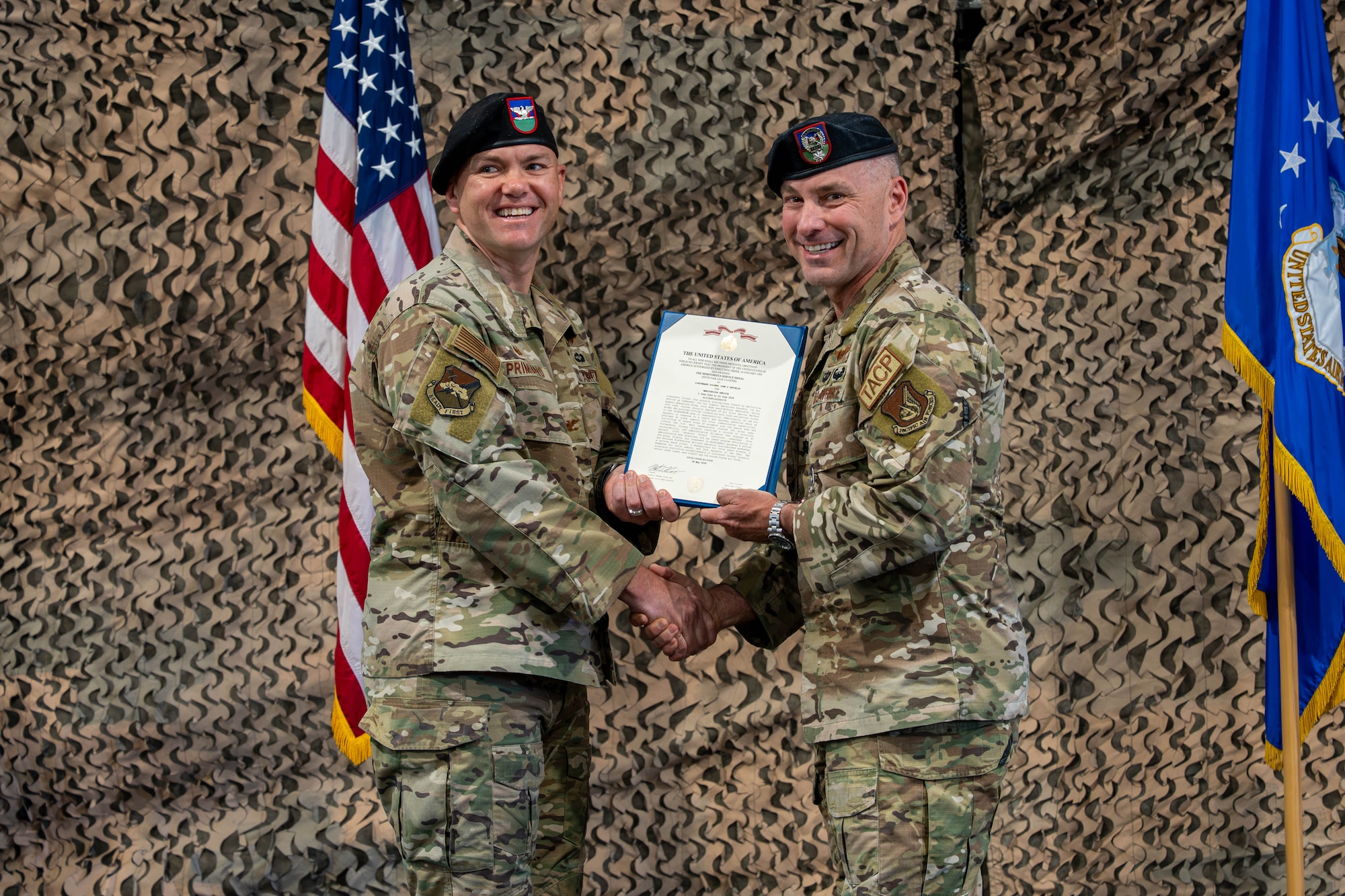 Two men stand holding an award.