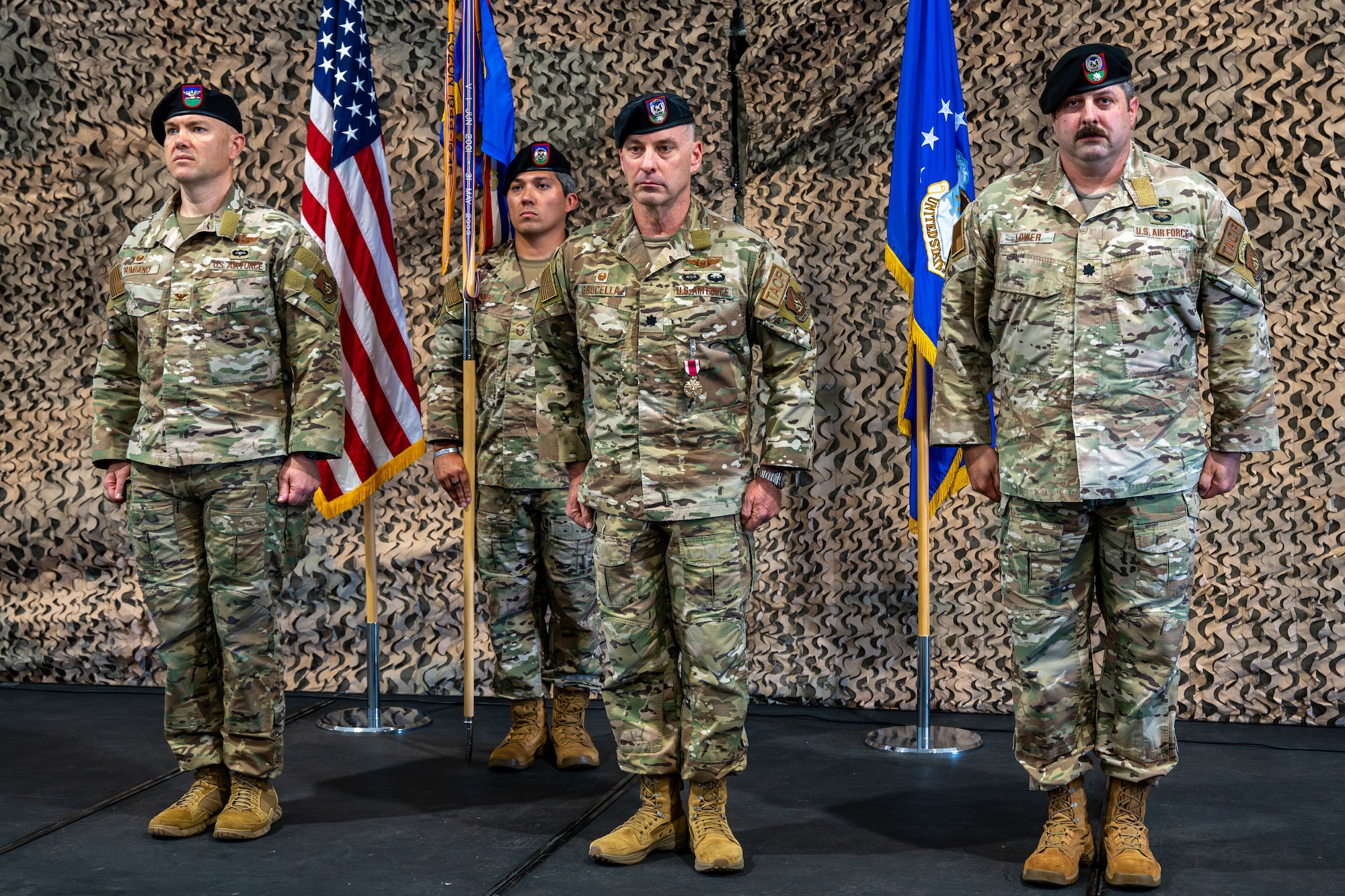 Three men stand on a stage.