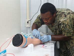Hospitalman Apprentice Michaiah Walker , assigned to Expeditionary Medical Facility Kilo, draws blood from a simulated casualty during a training at the NMCCL Healthcare Simulation and Bioskills Center, on June 23, 2026. EMF-Kilo is the expeditionary readiness platform attached to Navy Medicine Readiness and Training Command Camp Lejeune and is comprised of approximately hundreds of personnel ready to deploy field hospital capabilities during humanitarian or combat mission. (U.S. Navy photo by Mass Communications Specialist 2nd Class Justin Woods)