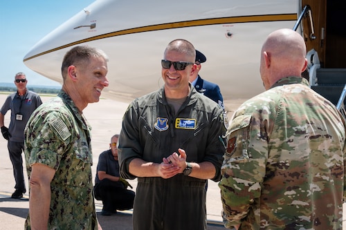 A U.S. Navy Admiral is greeted on the flightline