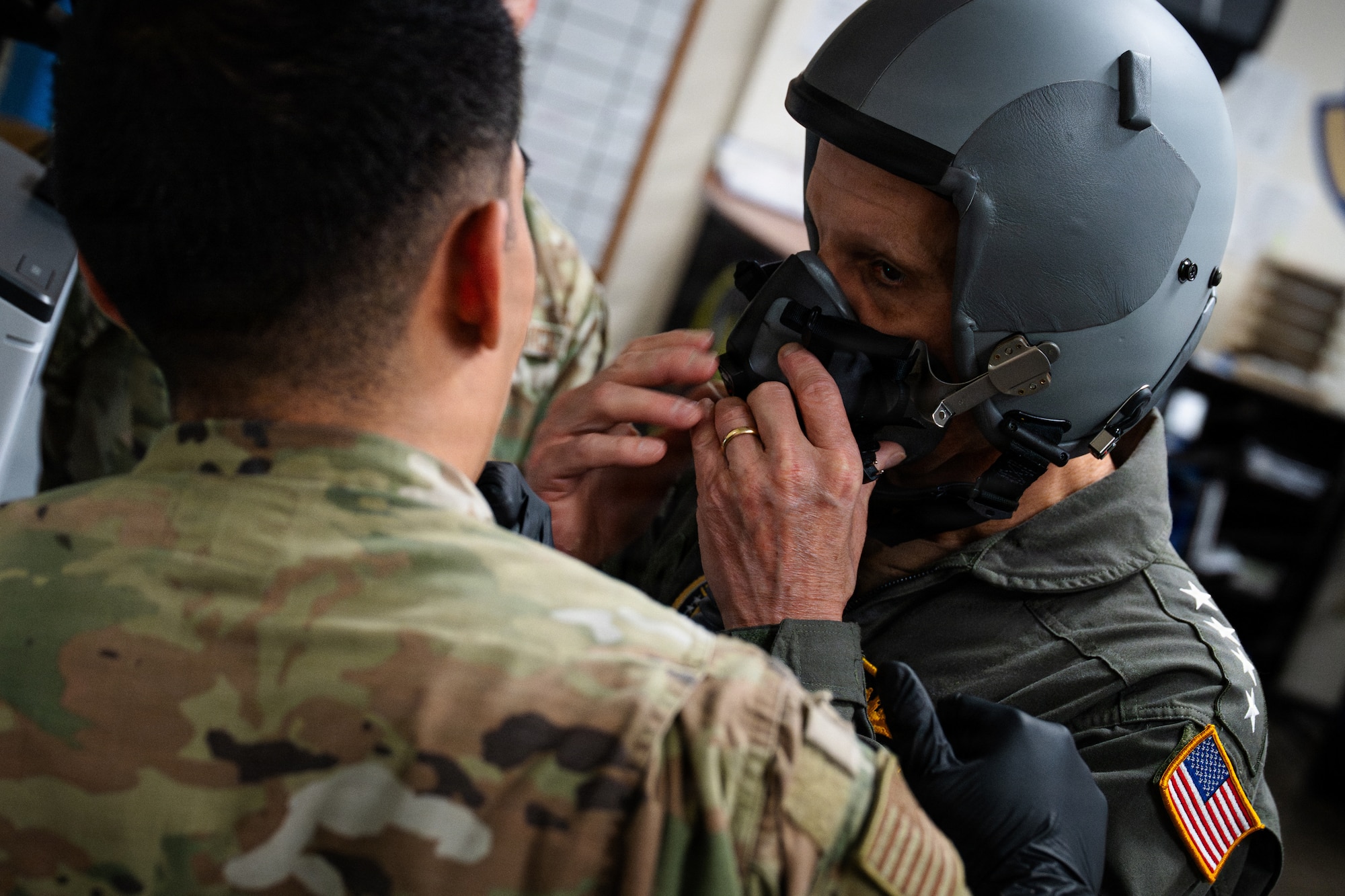 A U.S. Navy Admiral gets fitted for a flight helmet