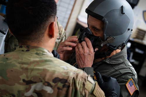 A U.S. Navy Admiral gets fitted for a flight helmet