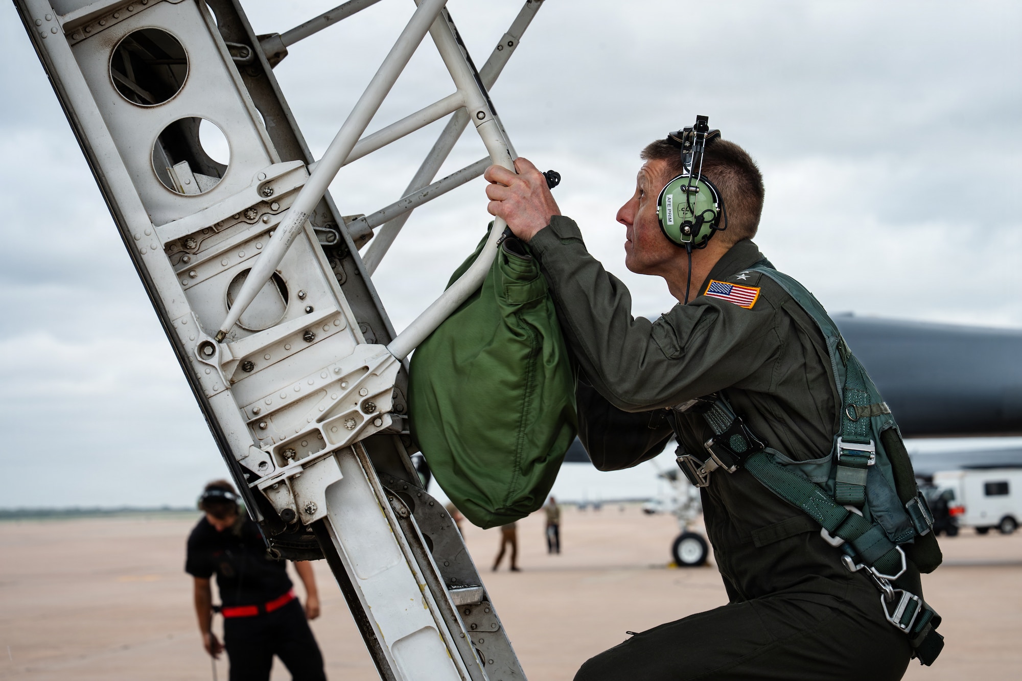 A U.S. Navy Admiral climbs into the cockpit of a B-1B Lancer.