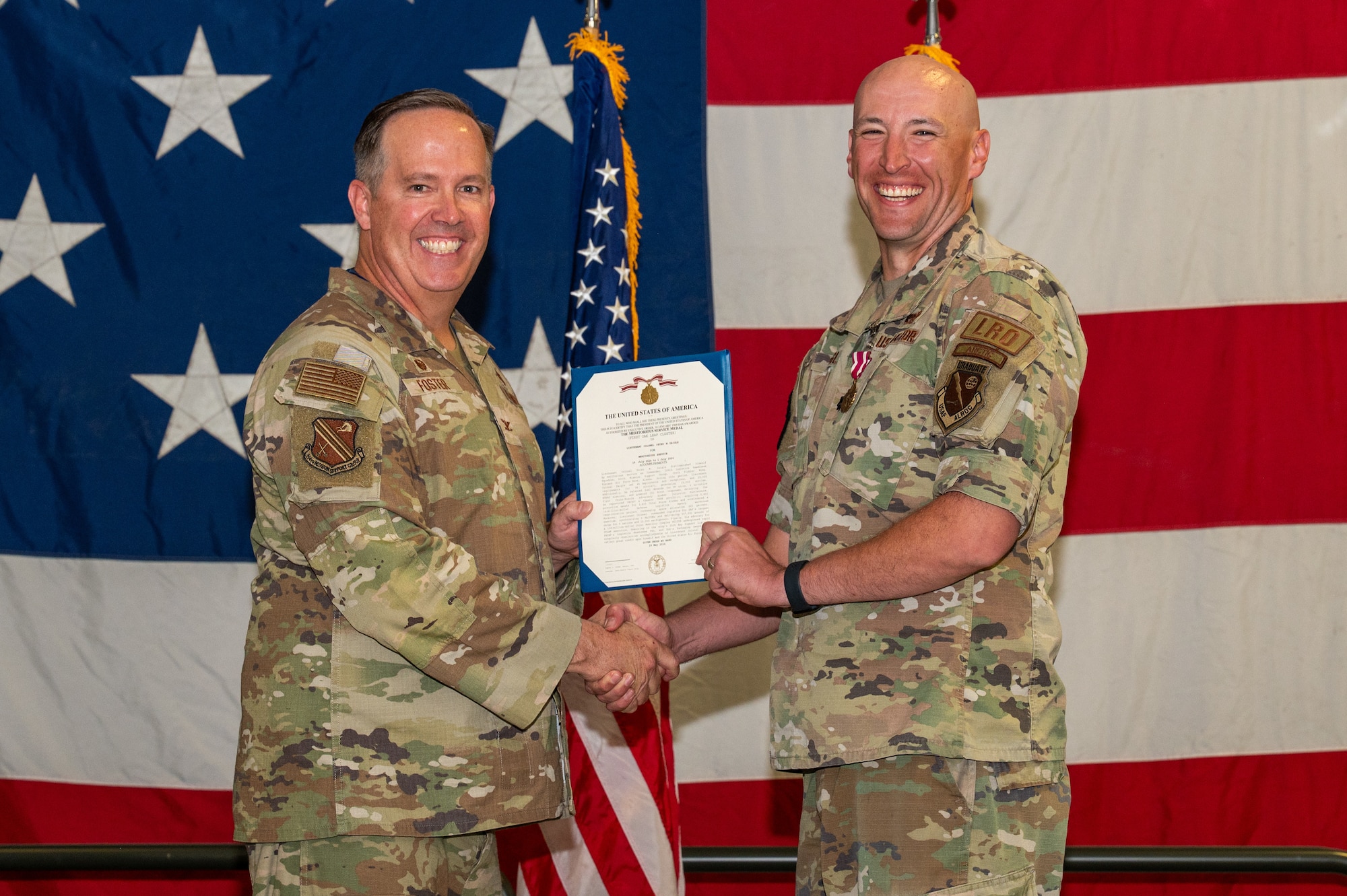 U.S. Air Force Col. Timothy Foster, 354th Mission Support Group commander, left, awards the Air Force meritorious service medal to Lt. Col. Peter Daigle, 354th Logistics Readiness Squadron outgoing commander, during a change of command ceremony at Eielson Air Force Base, Alaska, June 18, 2026.