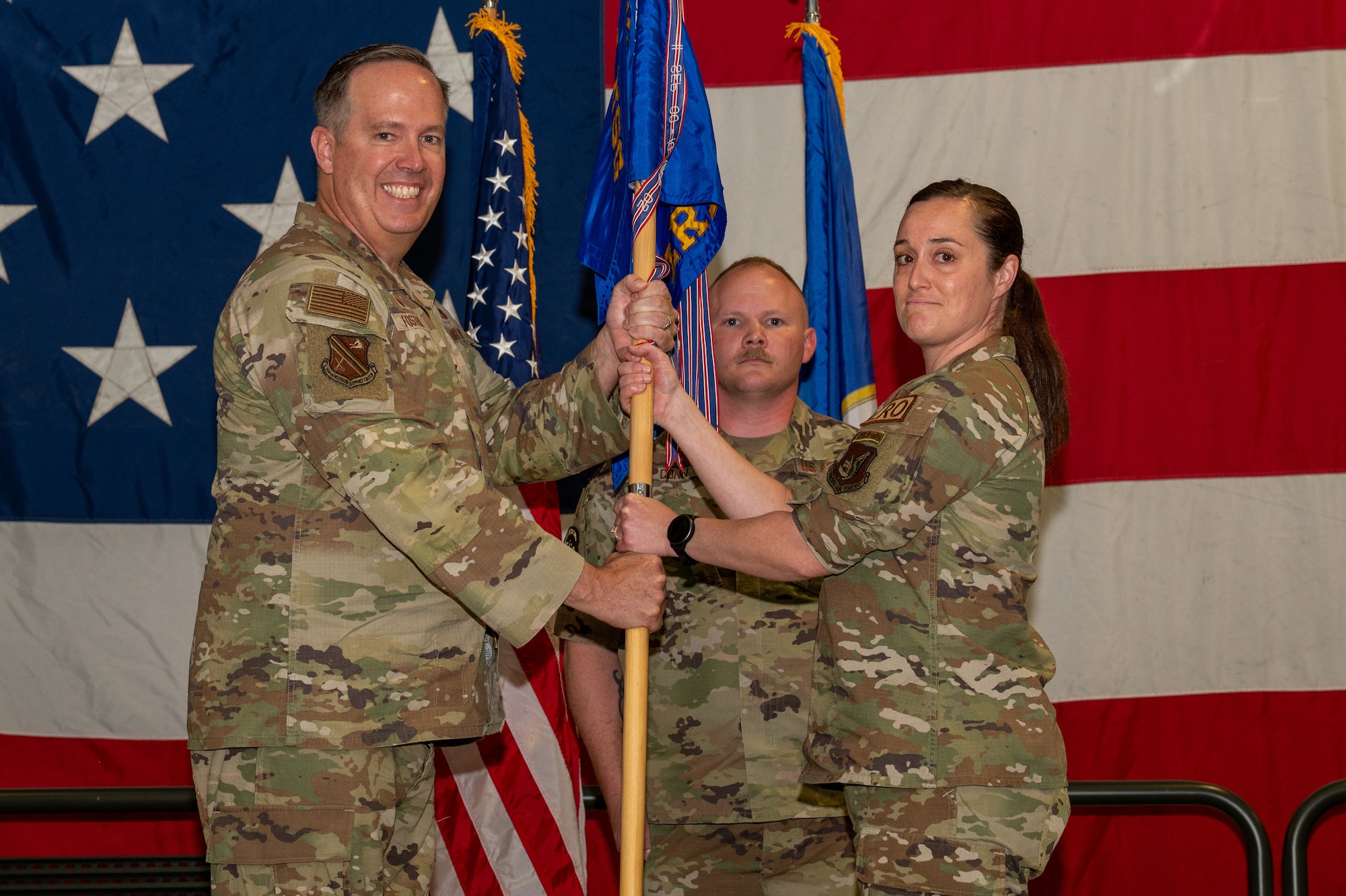 U.S. Air Force Col. Timothy Foster, 354th Mission Support Group commander, left, passes a guidon to Maj. Jessica Haskins, 354th Logistics Readiness Squadron incoming commander, during a change of command ceremony at Eielson Air Force Base, Alaska, June 18, 2026.