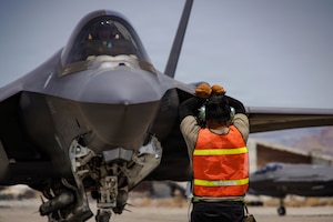 A U.S. Air Force F-35A Lightning II aircraft assigned to the 65th Aggressor Squadron gets marshalled on the flightline at Creech Air Force Base, Nevada, June 17, 2026. Exercise VENOM FORGE is an in-house, limited-scope, targeted event designed to develop and test critical thinking, planning and execution across the logistics enterprise, maintenance, munitions and logistics. (U.S. Air Force photo by Staff Sgt. Jake Jacobsen)
