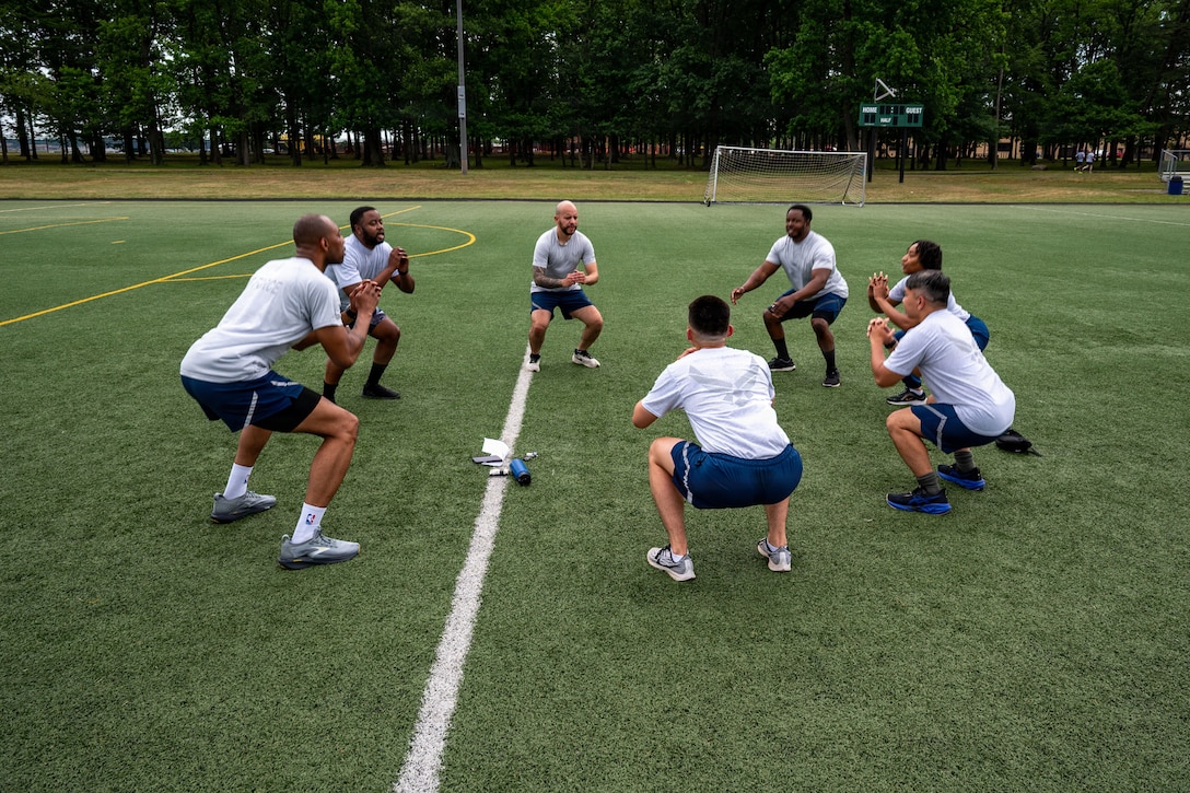 U.S. Airmen assigned to the 316th Force Support Squadron perform squats as part of their group physical training.