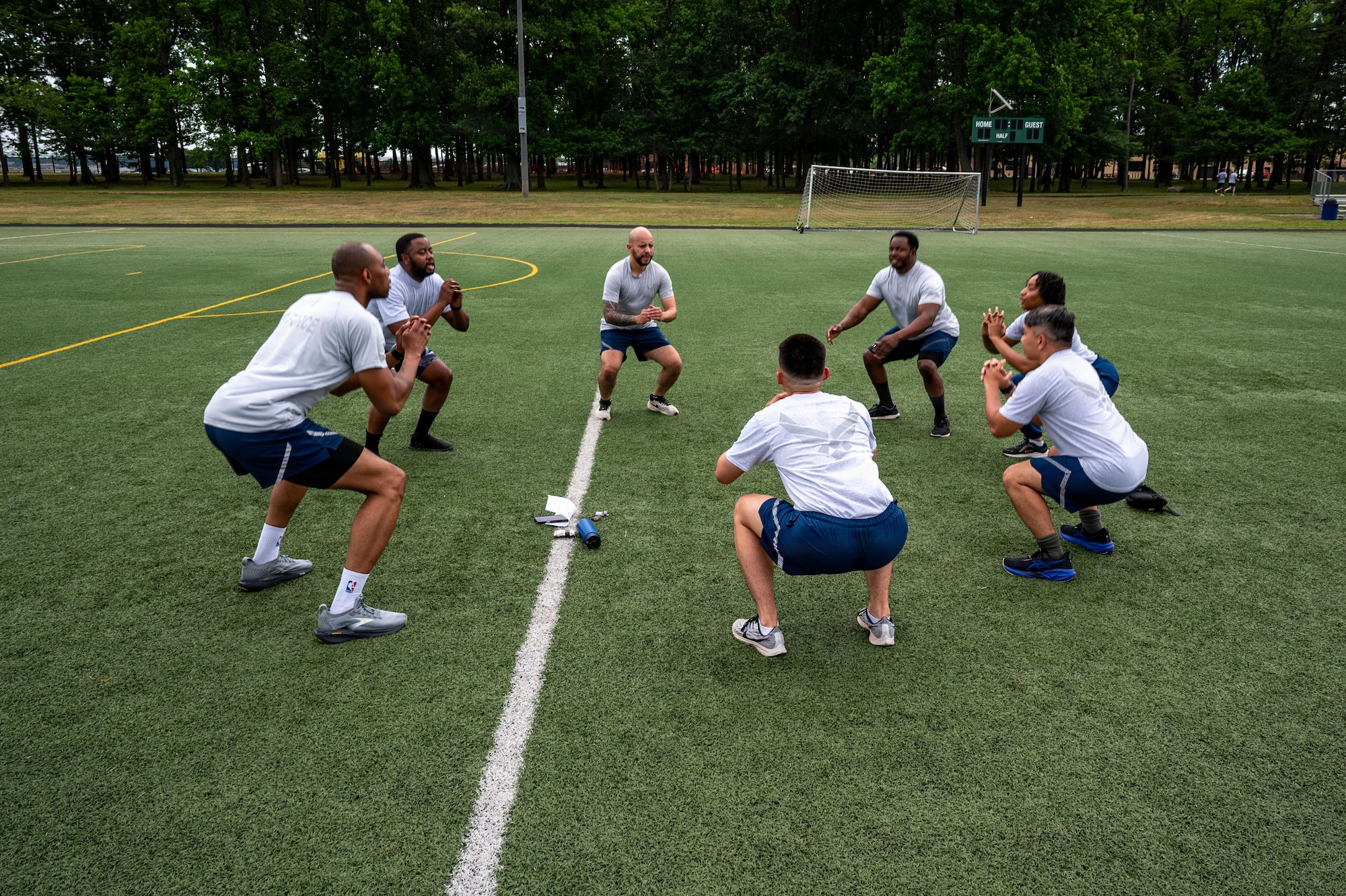 U.S. Airmen assigned to the 316th Force Support Squadron perform squats as part of their group physical training.