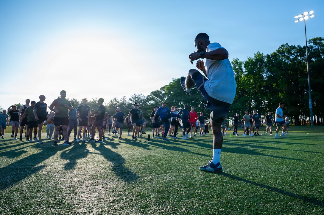 U.S. Air Force Staff Sgt. Myron Harrison, unit fitness program manager assigned to the 316th Civil Engineer Squadron, leads stretches.
