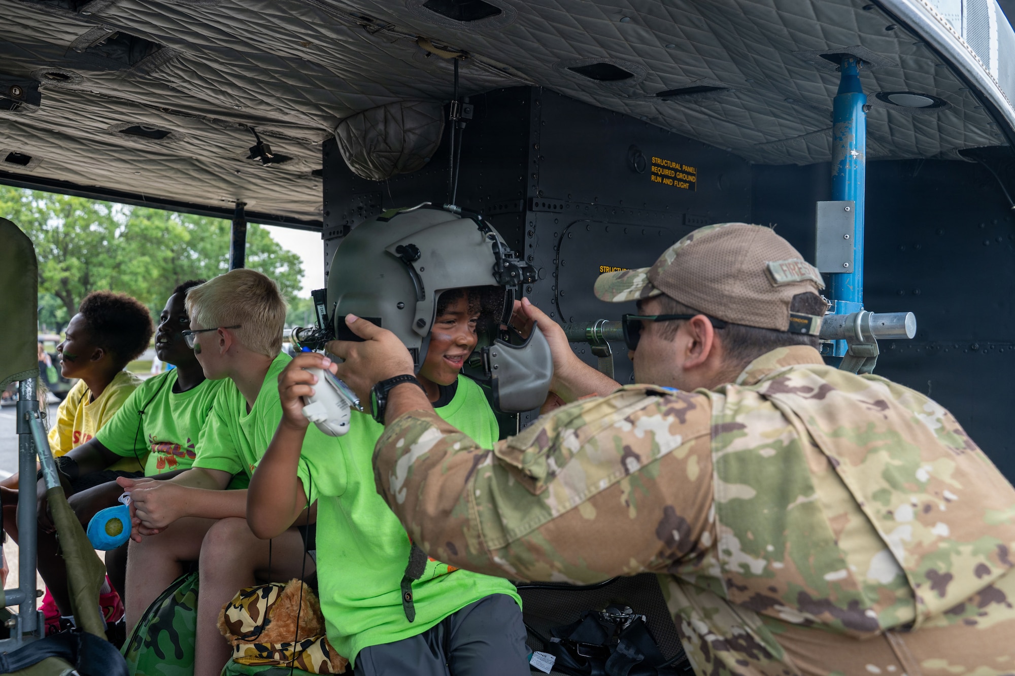 U.S. Air Force Airman 1st Class Li Runzhung, a financial operation technician to the 316th Wing , hands out pens to children