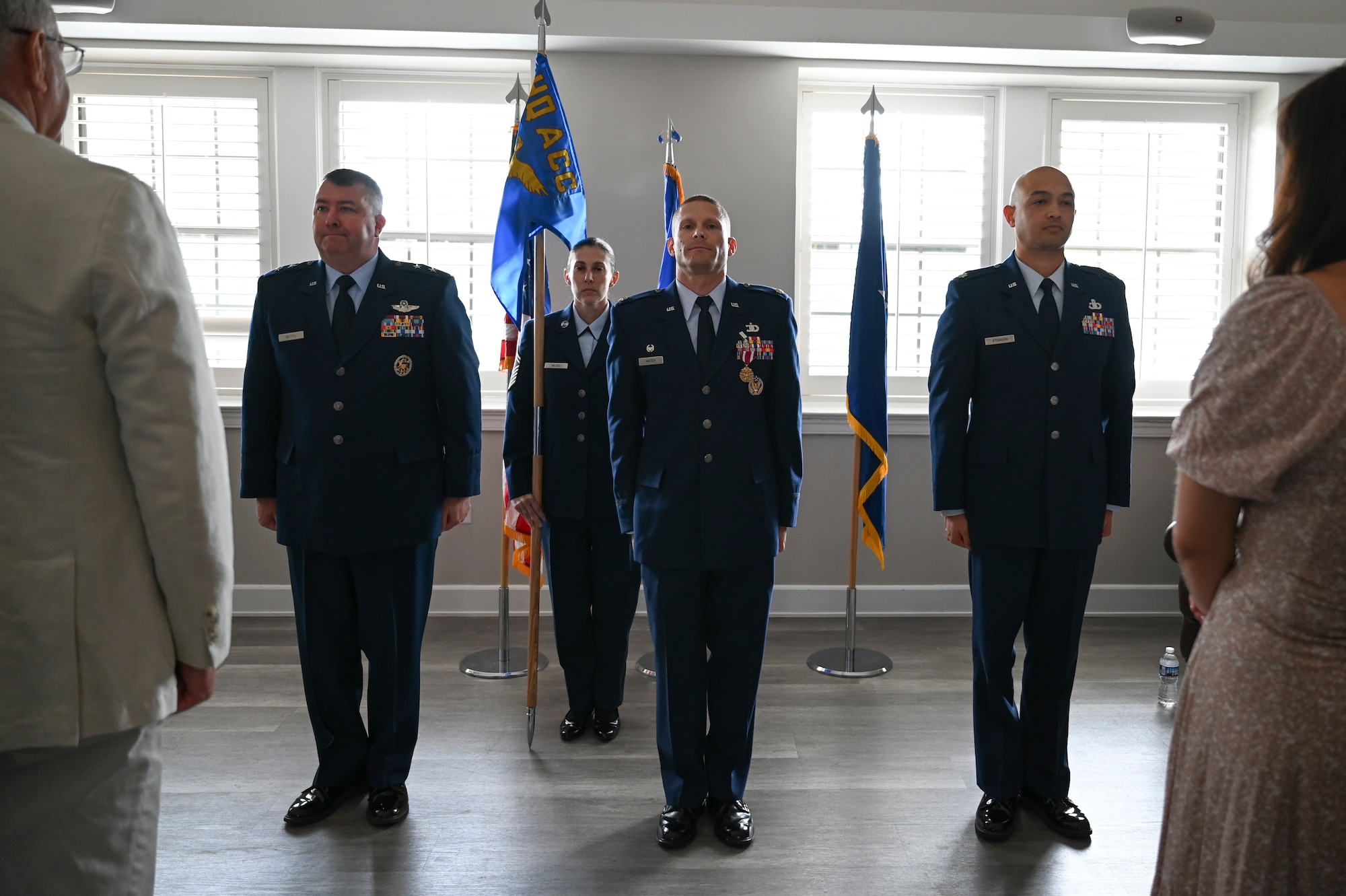 U.S. Air Force Lt. Col. Andrew Atkinson, right, incoming commander of the Air Combat Command Operations Analysis Squadron (OAS), Maj. Gen. William D. Betts, left, Director of Plans, Programs and Requirements, Headquarters ACC, and Lt. Col. Micah Hafich, outgoing commander of the ACC OAS, stand at attention during the ACC OAS change of command ceremony.