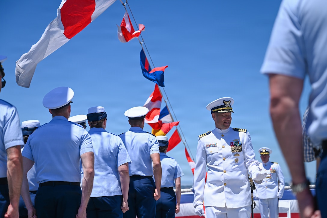 Capt. Adam J. Disque walks down the center aisle as the commanding officer of Coast Guard Cutter Munro (WMSL 755) for the first time following a change-of-command ceremony in San Diego, June 26, 2026. A change-of-command ceremony is a time-honored military tradition that formally transfers authority and responsibility from one commanding officer to another while reaffirming the continuity of command. (U.S. Coast Guard photo by Petty Officer 3rd Class Trinity Whalen)