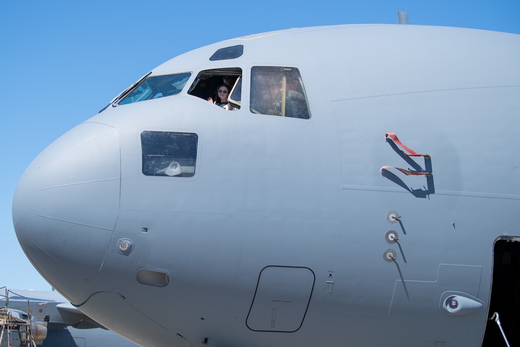 Woman sits inside airplane.