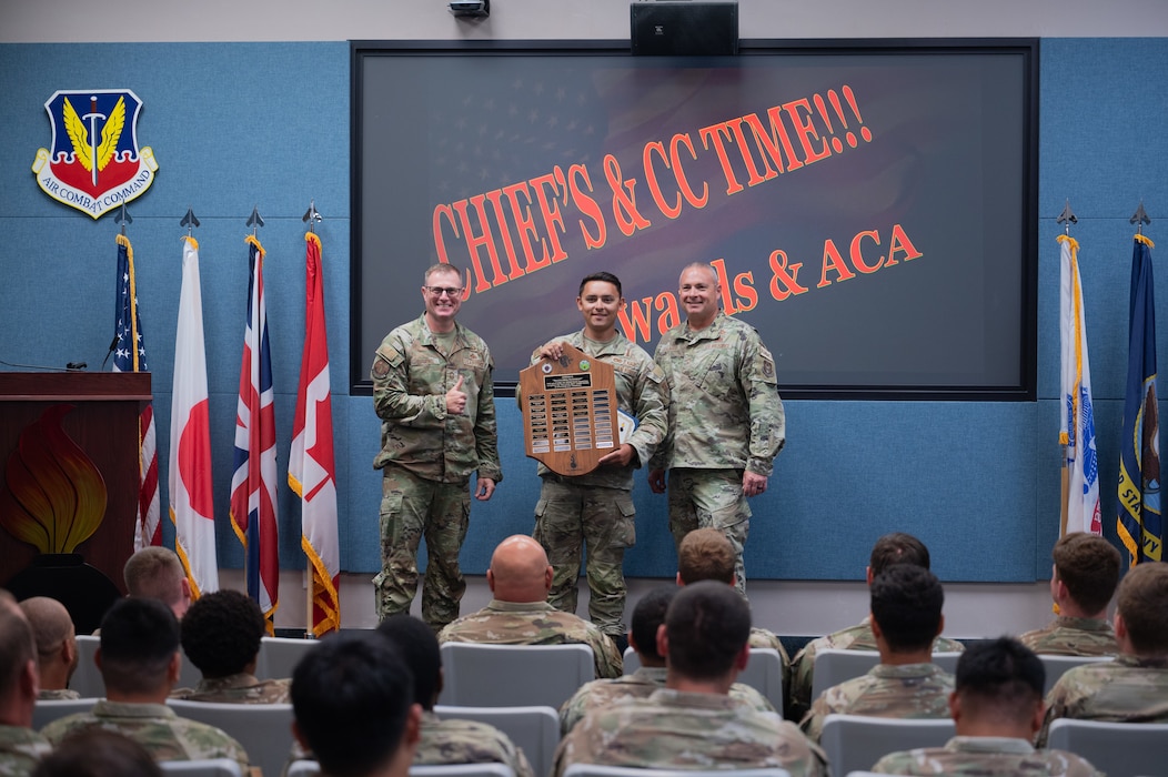 Chief Master Sgt. Anthony Diamond, left, and Chief Master Sgt. Russel Guajardo, right, present U.S. Air Force Staff Sgt. Brendan Krings with the outstanding performer award during a graduation ceremony at Beale Air Force Base, California, June 19, 2026.