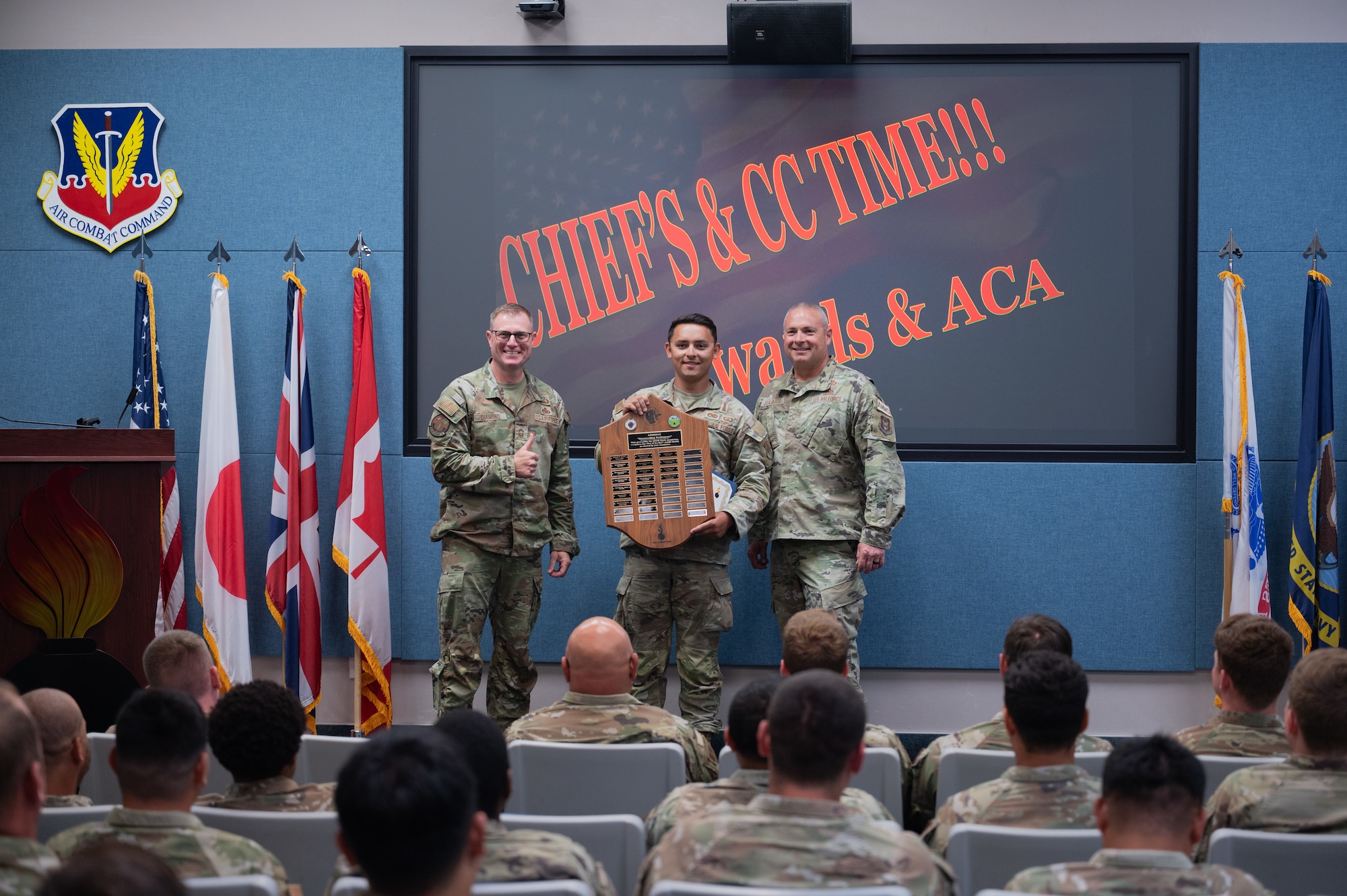 Chief Master Sgt. Anthony Diamond, left, and Chief Master Sgt. Russel Guajardo, right, present U.S. Air Force Staff Sgt. Brendan Krings with the outstanding performer award during a graduation ceremony at Beale Air Force Base, California, June 19, 2026.