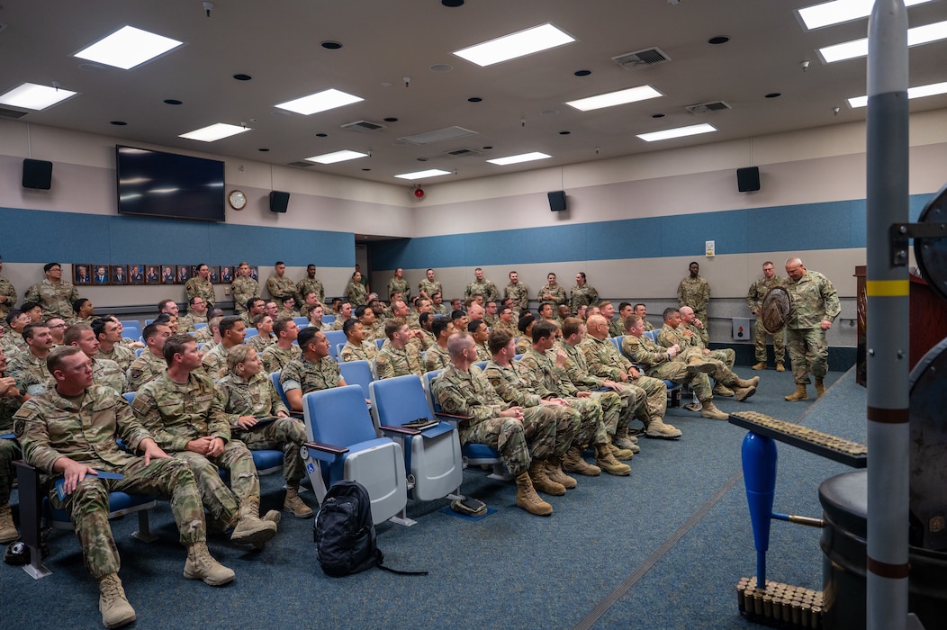 Students assigned to the Air Force Combat Ammunition Center Class 26-006 listen to remarks from Chief Master Sgt. Russel Guajardo, command munitions functional manager with Headquarters Air Force Reserve Command, during their graduation ceremony at Beale Air Force Base, California, June 19, 2026.