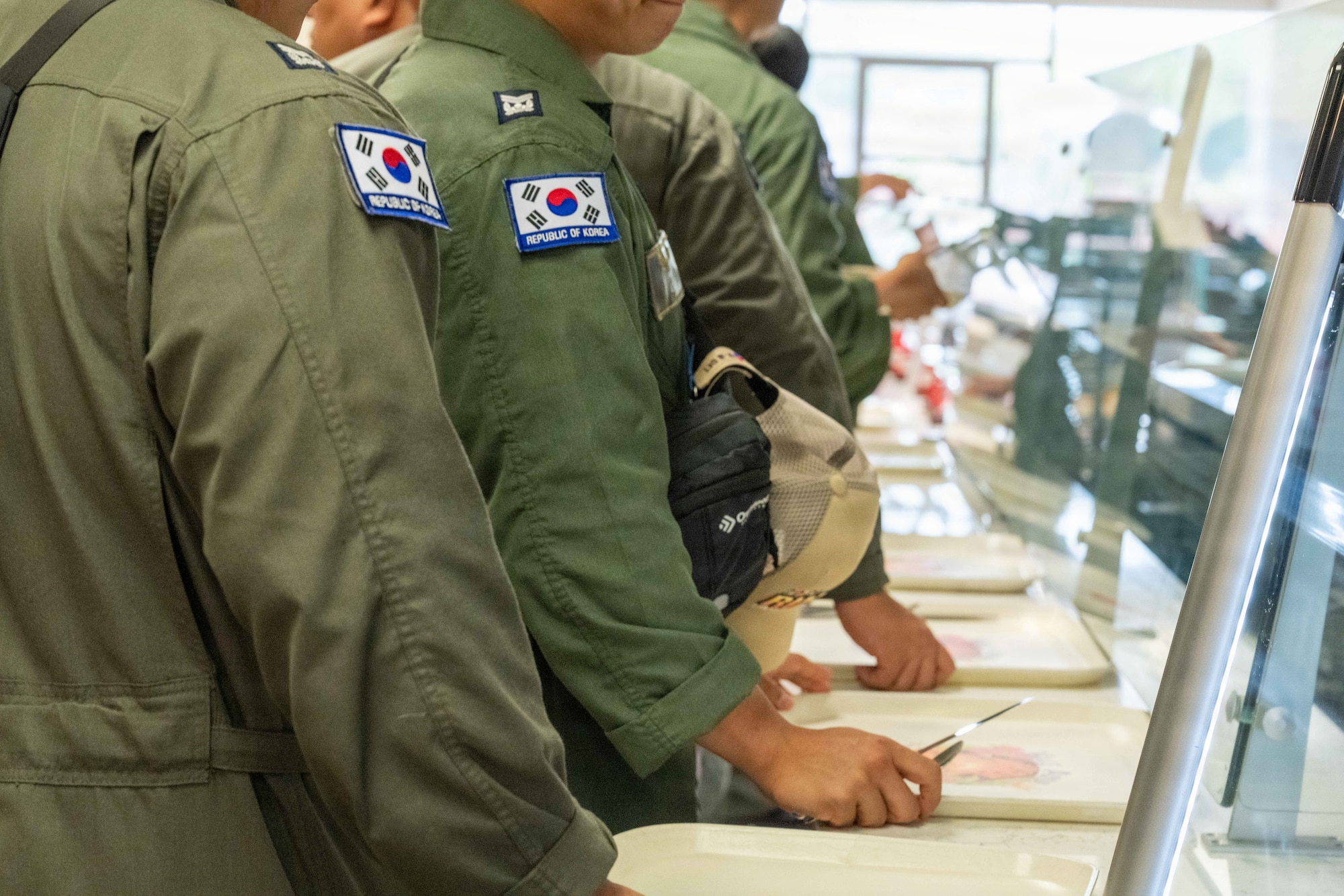 Republic of Korea Navy sailors wait in line for a meal at the Hale ʻAina Dining Facility at Joint Base Pearl Harbor-Hickam, Hawaii, June 26, 2026. The Hale ʻAina Dining Facility provides nutritious meal options to authorized patrons, including U.S. service members, partner nation personnel and other individuals with dining privileges on the installation. (U.S. Air Force photo by Staff Sgt. Mark Sulaica)