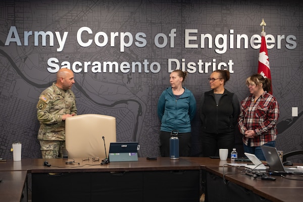 Sacramento District Commander Col. Robert McTighe (left) presents a commander's coin to (from left) Shelley McCoy, Jerilynn Hilmar and Elizabeth "Ellie" Hayes Dec. 8, 2025, at Sacramento District headquarters. The three employees were recognized for their quick response to a medical emergency, drawing on their training and past experiences to assist a distressed colleague and help facilitate the medical attention she needed