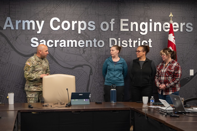 Sacramento District Commander Col. Robert McTighe (left) presents a commander's coin to (from left) Shelley McCoy, Jerilynn Hilmar and Elizabeth "Ellie" Hayes Dec. 8, 2025, at Sacramento District headquarters. The three employees were recognized for their quick response to a medical emergency, drawing on their training and past experiences to assist a distressed colleague and help facilitate the medical attention she needed