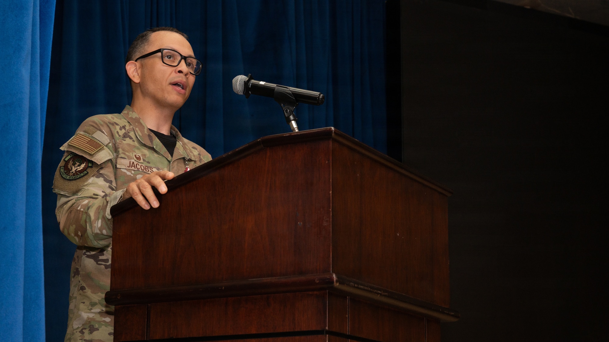A man gives a speech behind a podium.