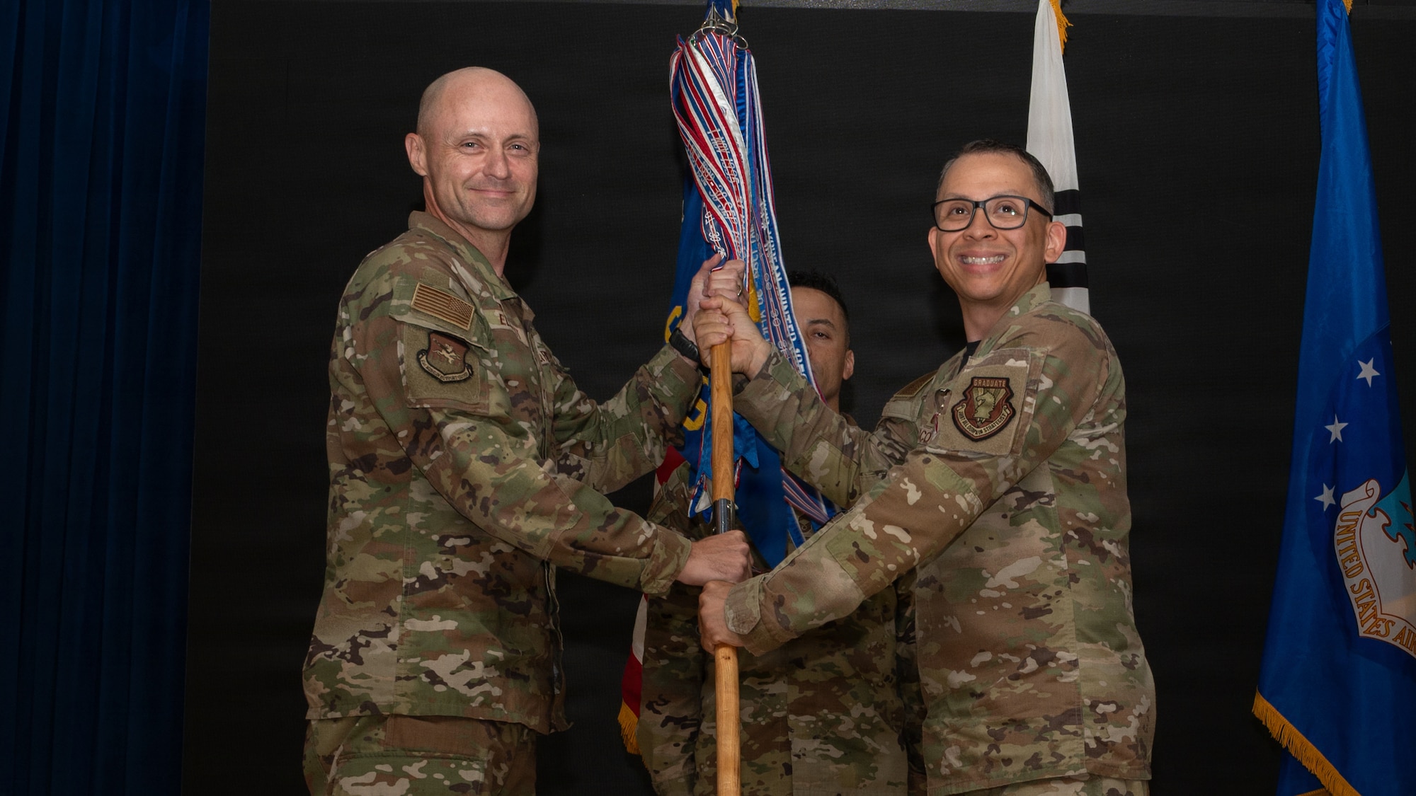 A guidon is passed between two men.