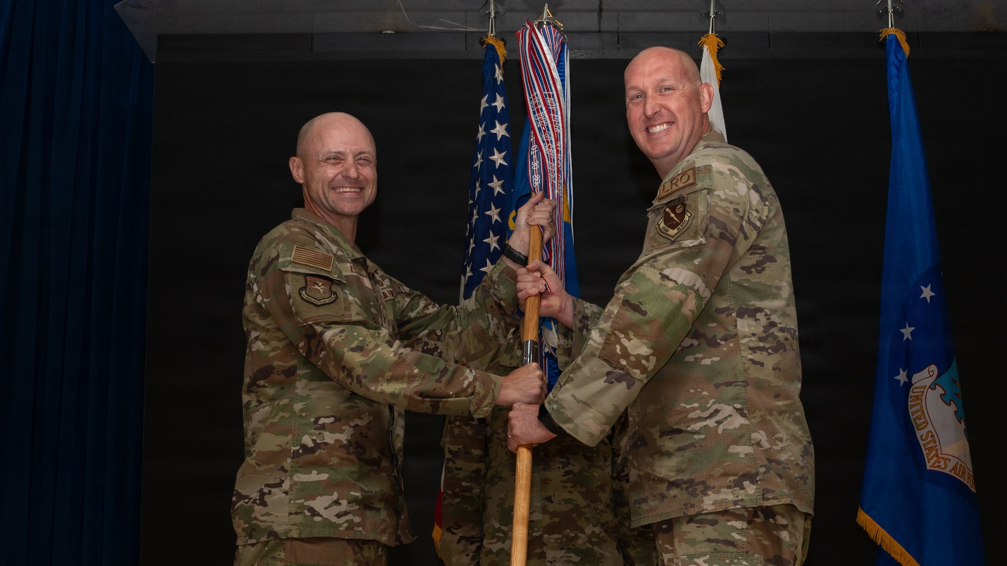 A guidon is passed between two men.