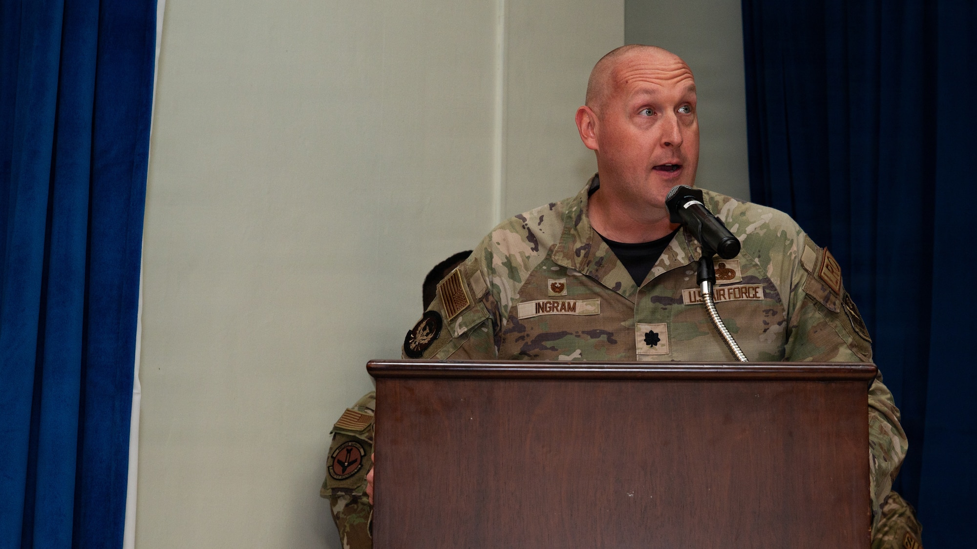 A man speaks behind a podium.