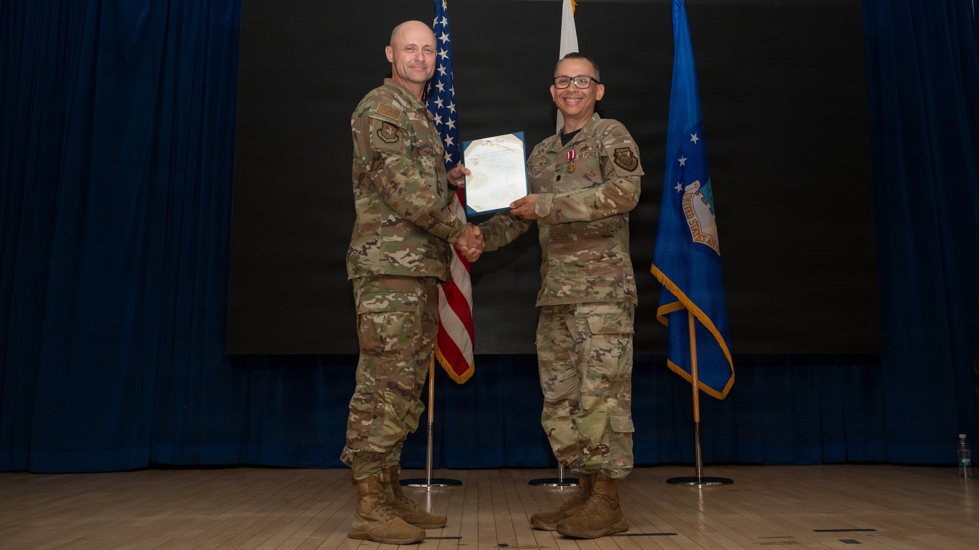Two men pose with an award.