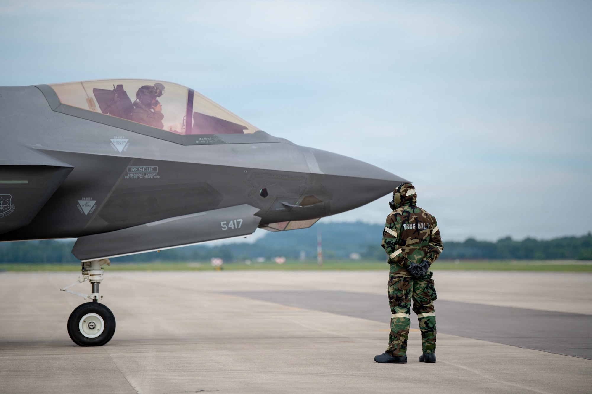 A U.S. Airman assigned to the 115th Fighter Wing, Wisconsin Air National Guard, conducts flight line operations in mission-oriented protective posture gear during a combat readiness exercise, Operation Iron Orchid, at Volk Field Air National Guard Base, Camp Douglas, Wisconsin, June 26, 2026. Operation Iron Orchid is designed to assess and reinforce the wing’s ability to generate combat capability, sustain operations, protect personnel and resources, respond to evolving conditions, and execute mission-essential tasks in a realistic and challenging environment. (U.S. Air National Guard photo by Airman Alec Martin)