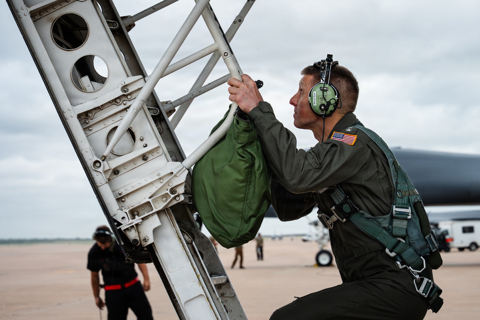 A U.S. Navy Admiral climbs into the cockpit of a B-1B Lancer.