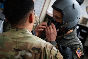 A U.S. Navy Admiral gets fitted for a flight helmet